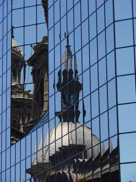 Reflets de la cathédrale dans une façade d'immeuble moderne